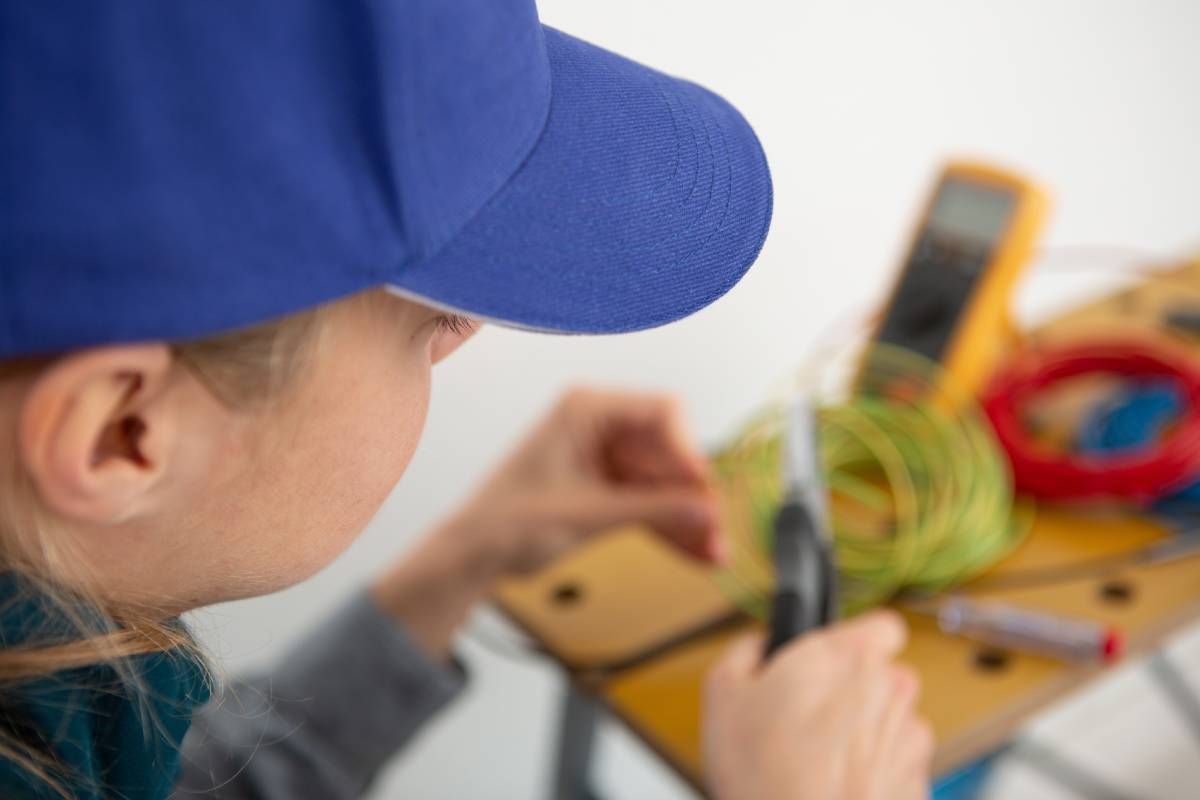 A low voltage technician checking the voltage in a wall fixture near Lexington, KY