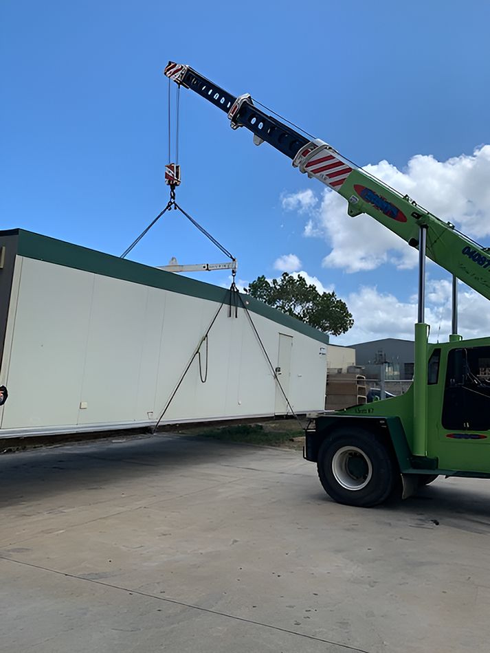 A Green Crane is Lifting a White Container — NQ Trading in Townsville, QLD