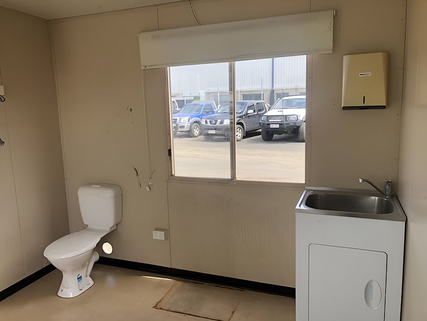 A Bathroom With a Toilet, Sink and Window — NQ Trading in Brisbane, QLD