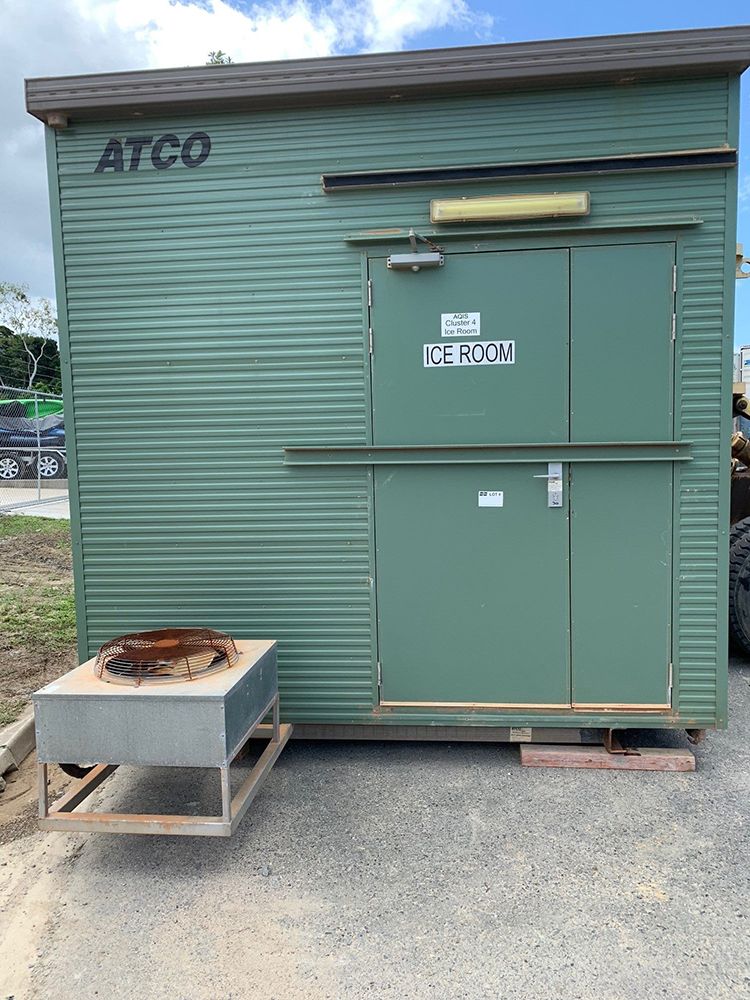 A Green Building With a Fire Pit in Front of It — NQ Trading in Edmonton QLD