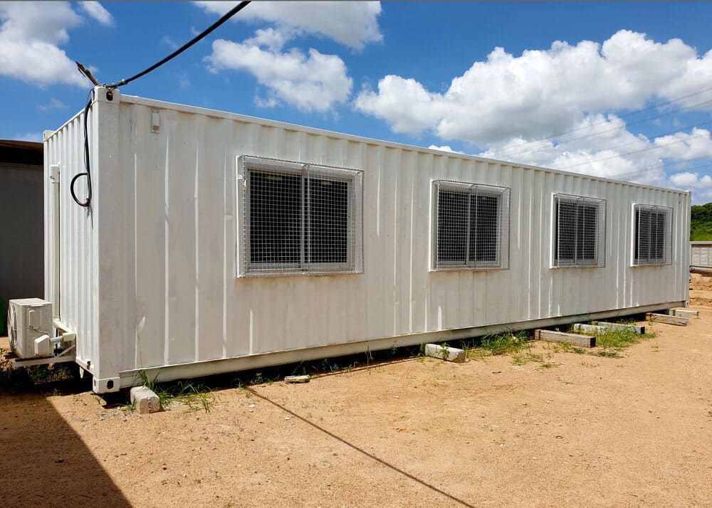 A White Shipping Container With A Lot Of Windows Is Sitting In A Dirt Field — NQ Trading In Edmonton, QLD