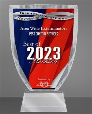 Award for Area Wide Exterminators. A clear trophy with a blue and red background, labeled