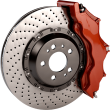 A close up of a brake disc with a red brake caliper