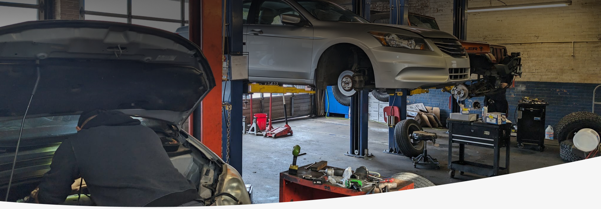 A car is sitting on a lift in a garage.