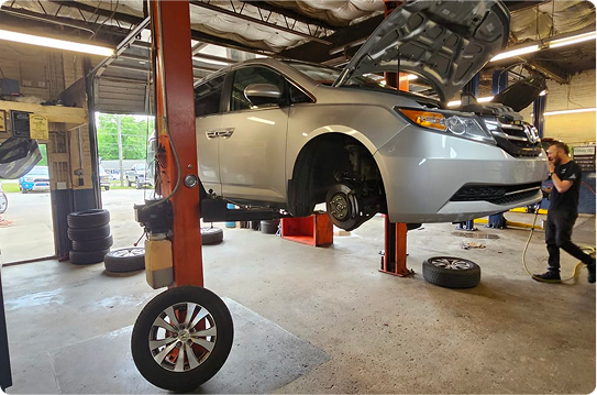 A car is sitting on a lift in a garage.