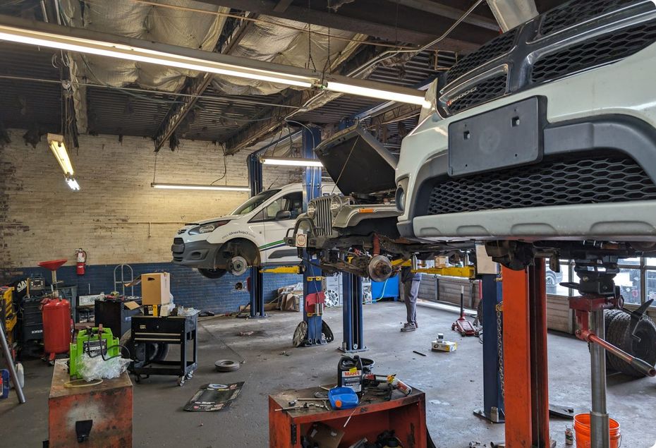 A car is sitting on a lift in a garage.