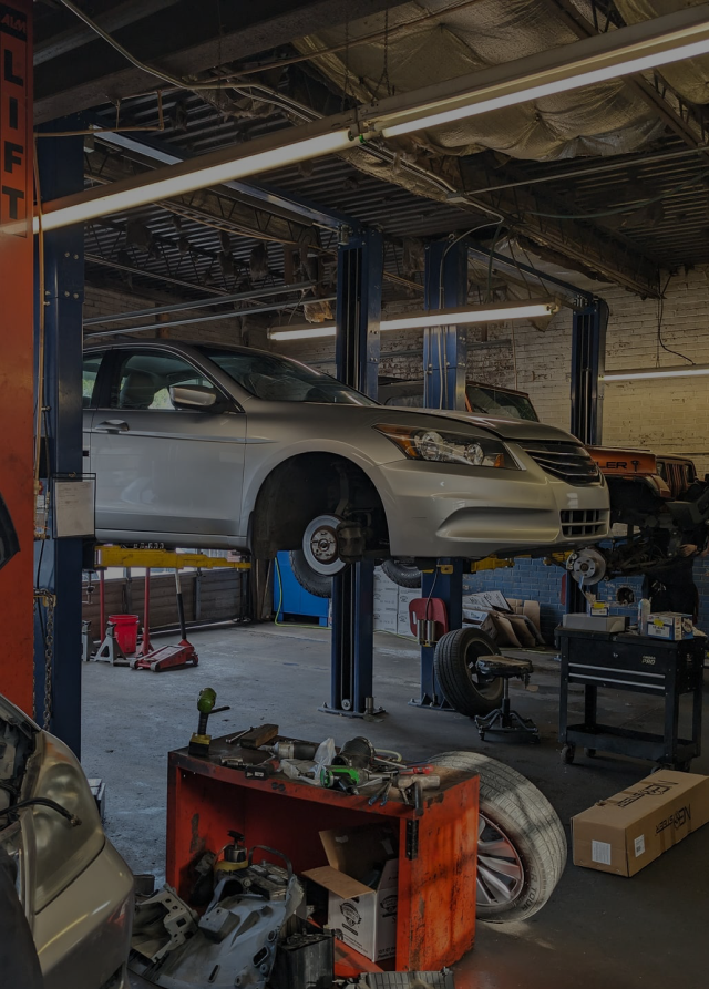 A car is sitting on a lift in a garage.