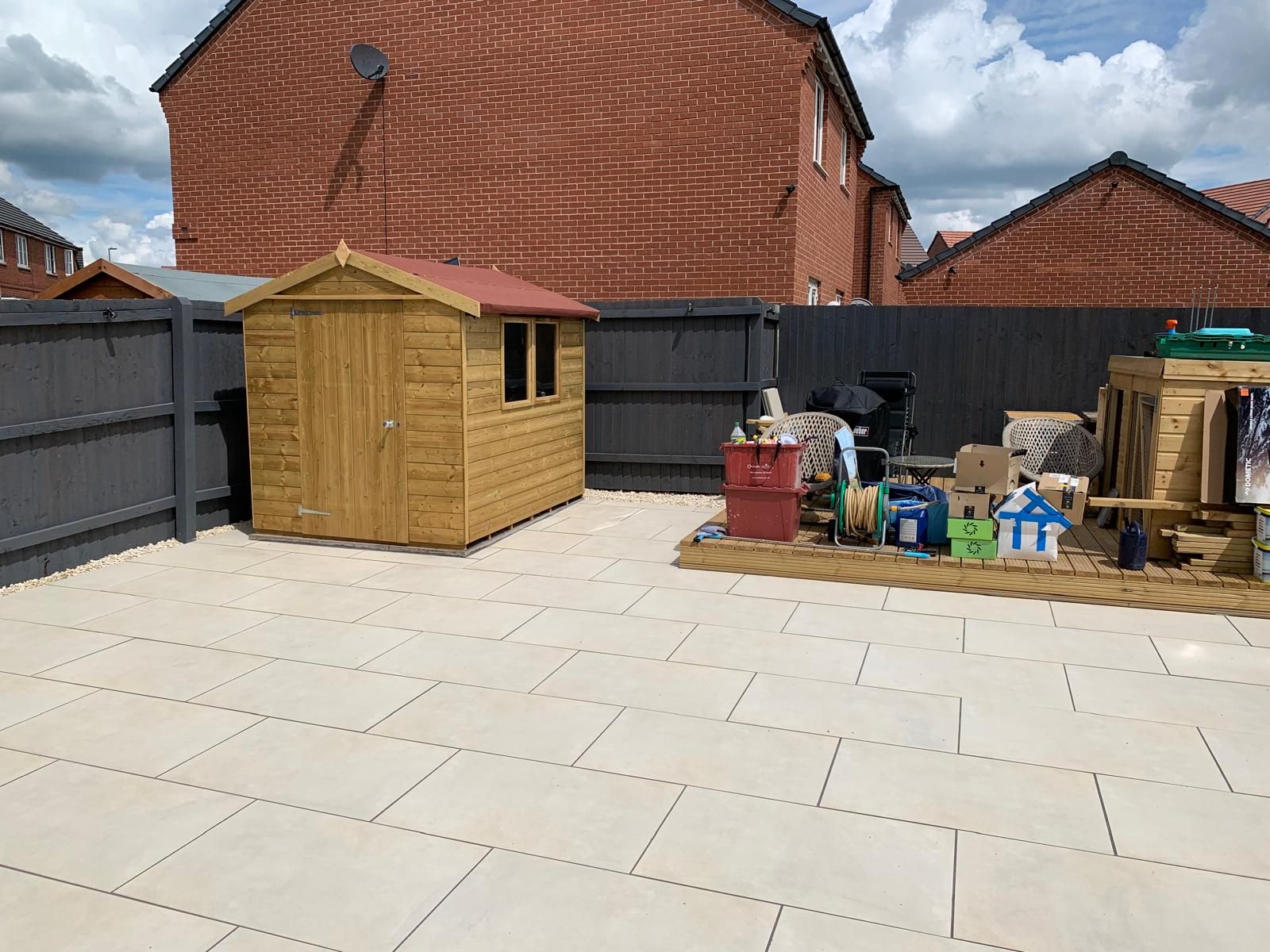 A backyard with a wooden shed and a fence surrounding it.