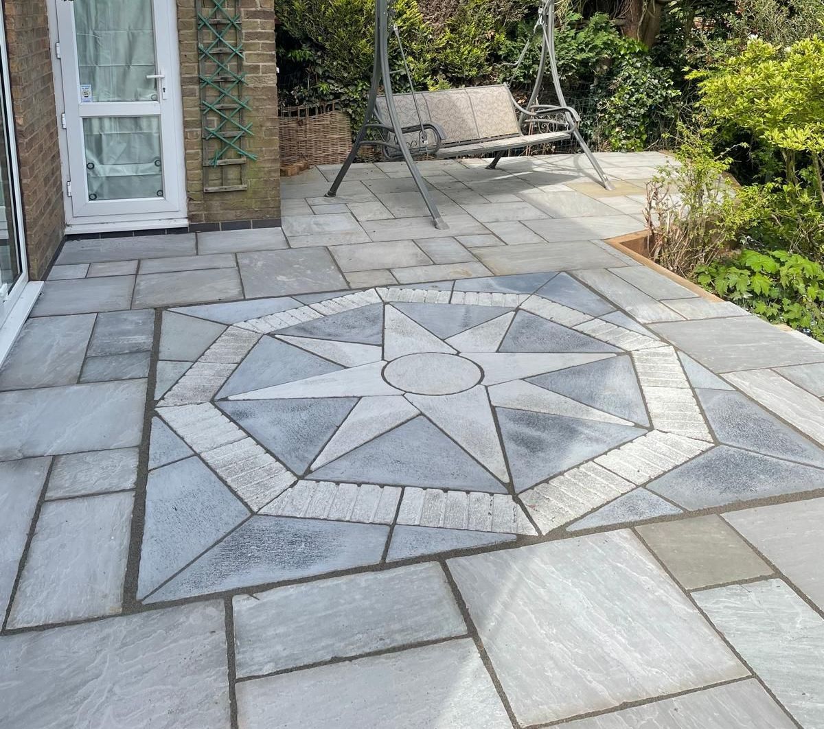 A patio with a bench and a swing on it