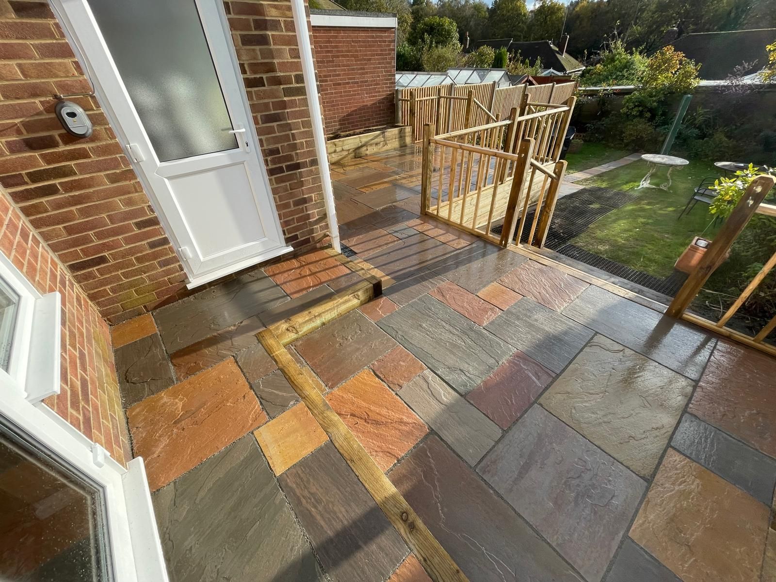 A brick house with a patio and stairs leading up to it.