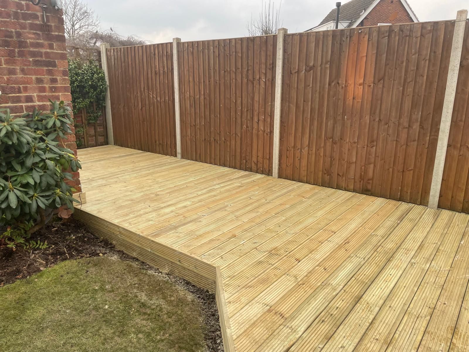 A wooden deck with a wooden fence in the background.