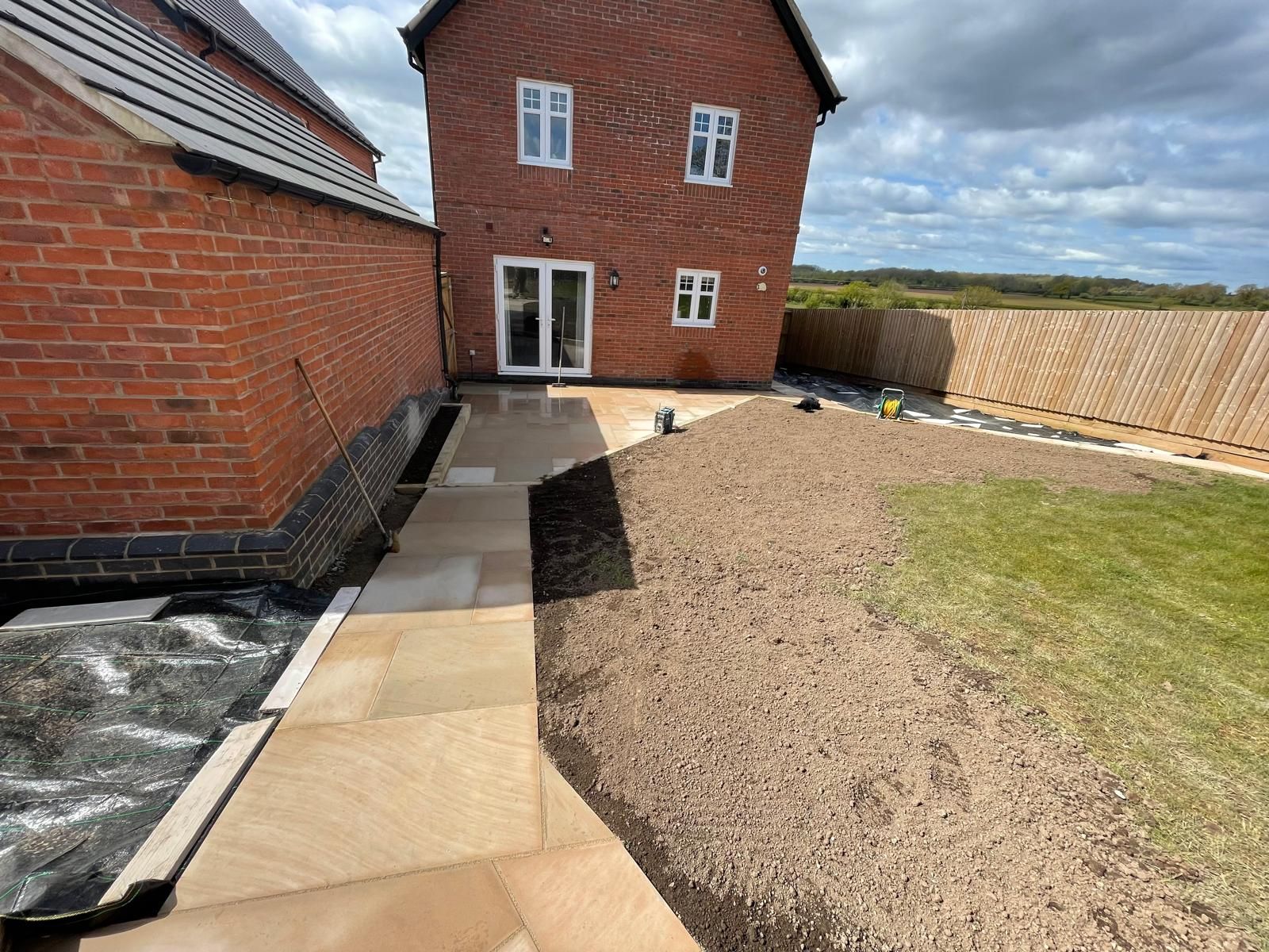 A brick house with a patio in front of it.