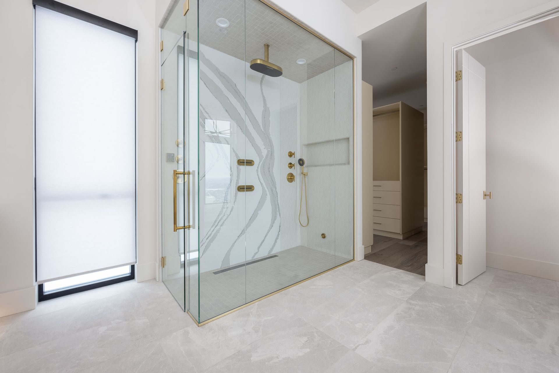 A bathroom with a walk in shower and a walk in closet.