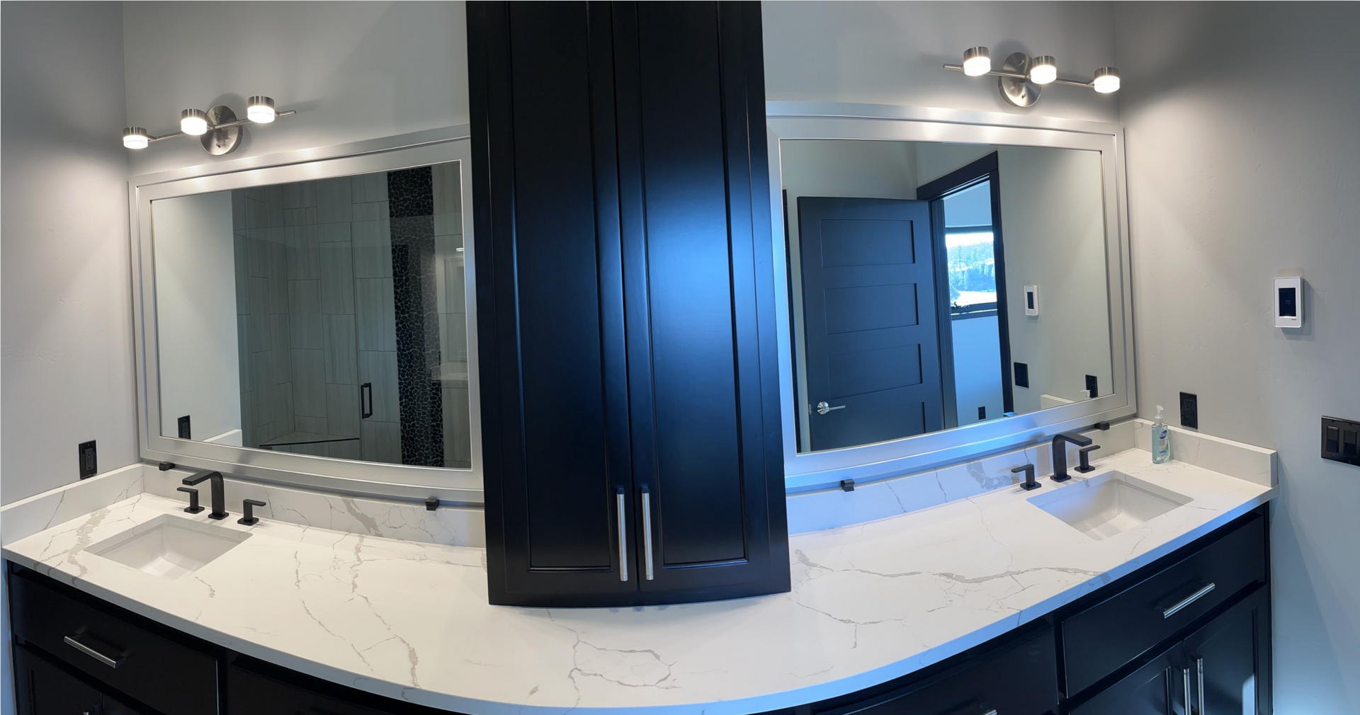 A bathroom with two sinks and two mirrors.