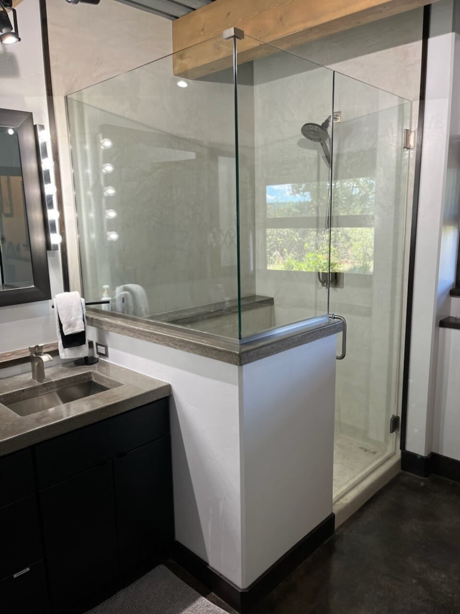 A bathroom with a walk in shower and a sink.