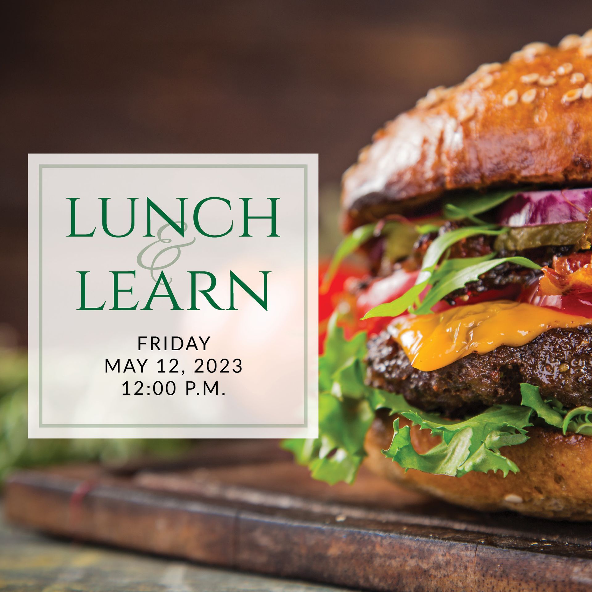 A hamburger is sitting on a wooden cutting board with the words lunch & learn on it