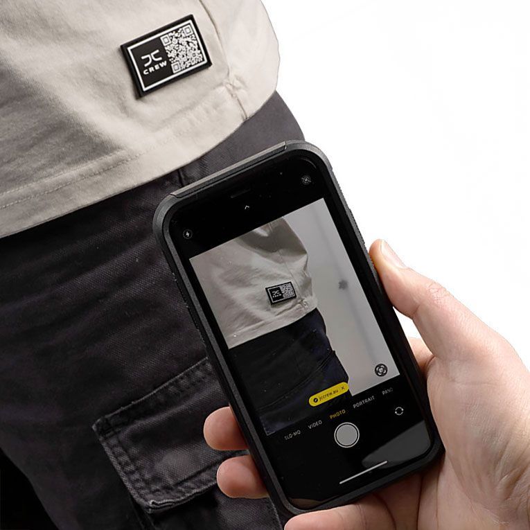 A person scans a QR code patch on a shirt with a smartphone.