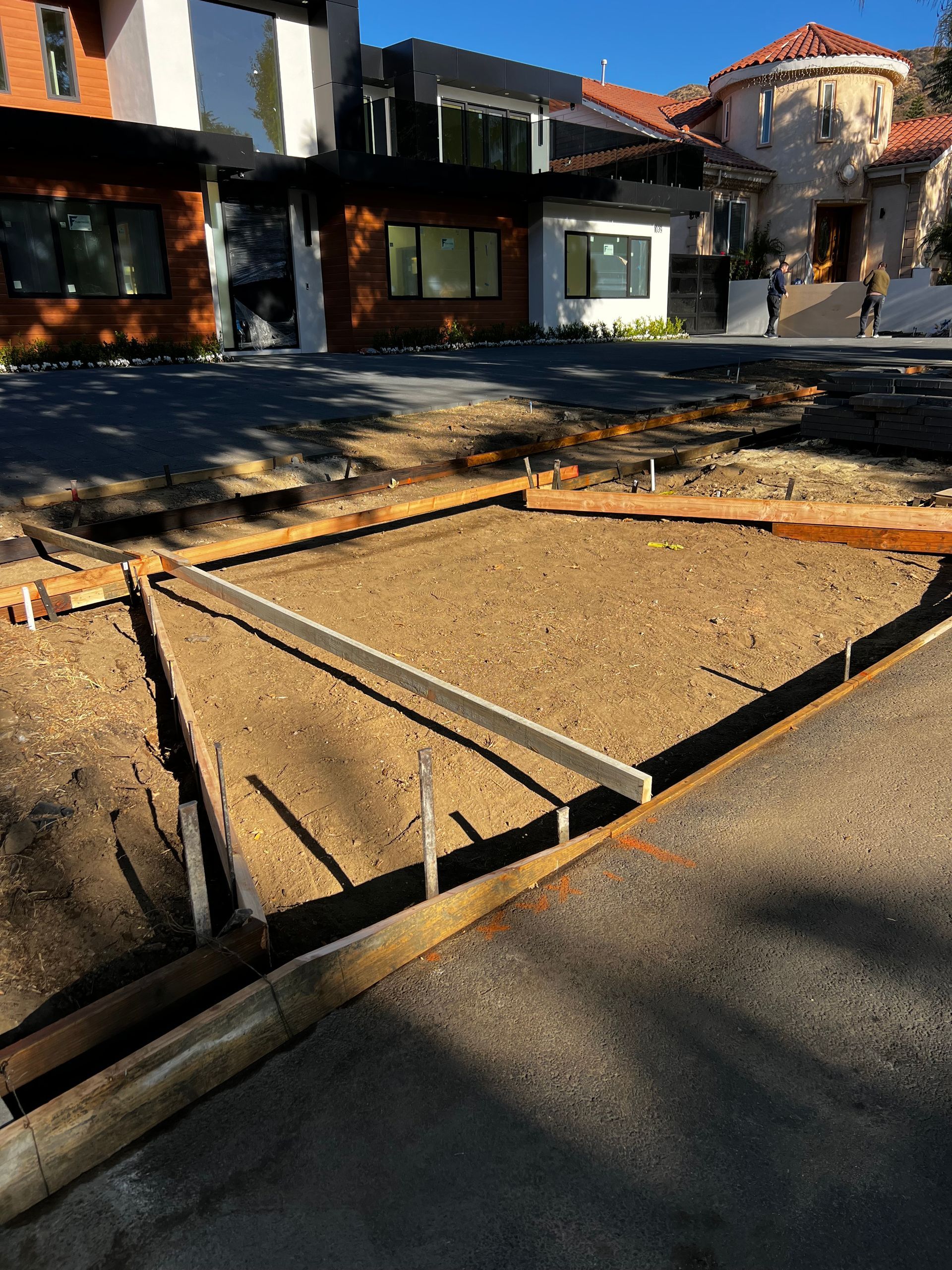A concrete driveway is being built in front of a house.