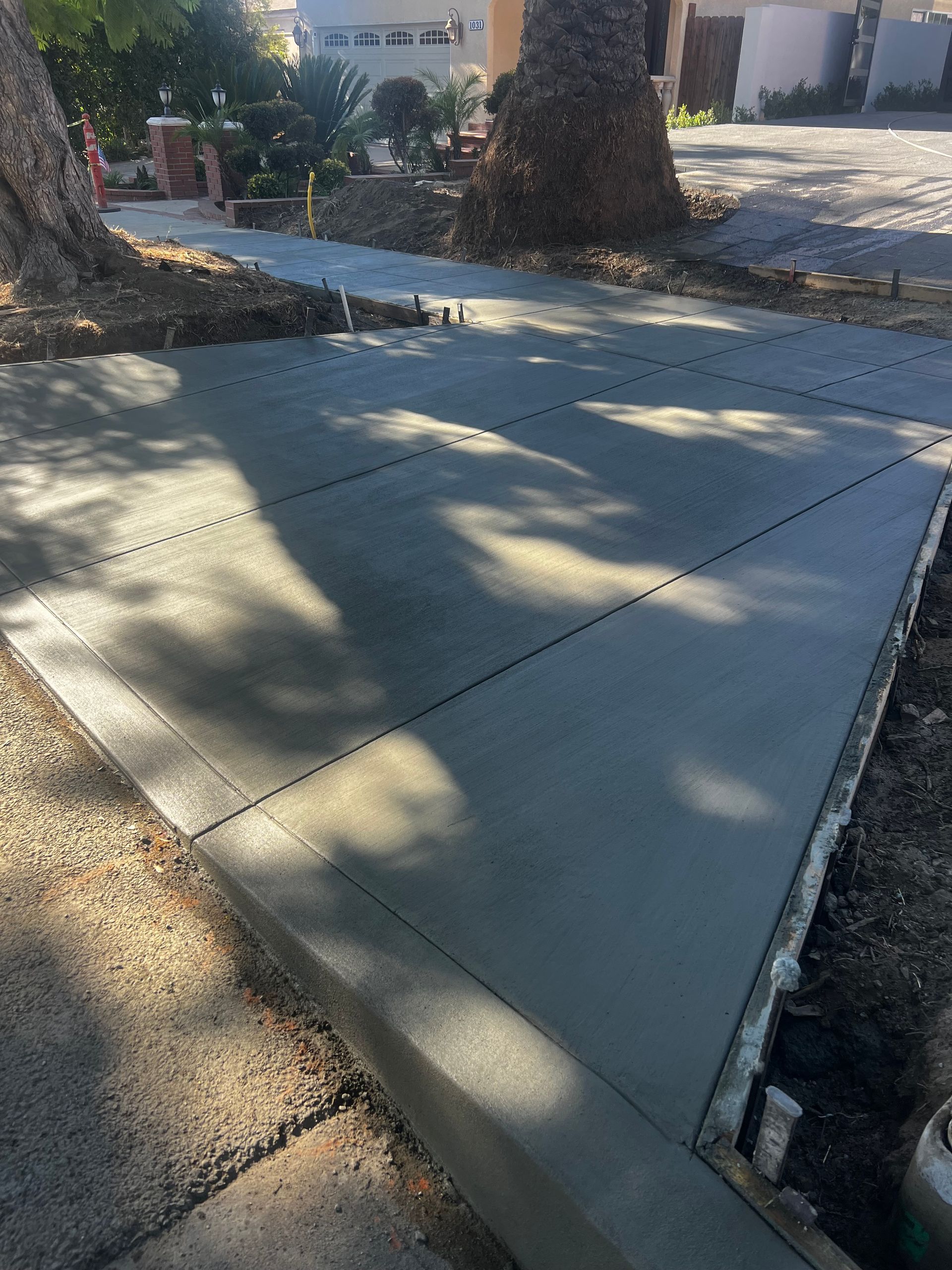 A concrete sidewalk is being built in front of a house.