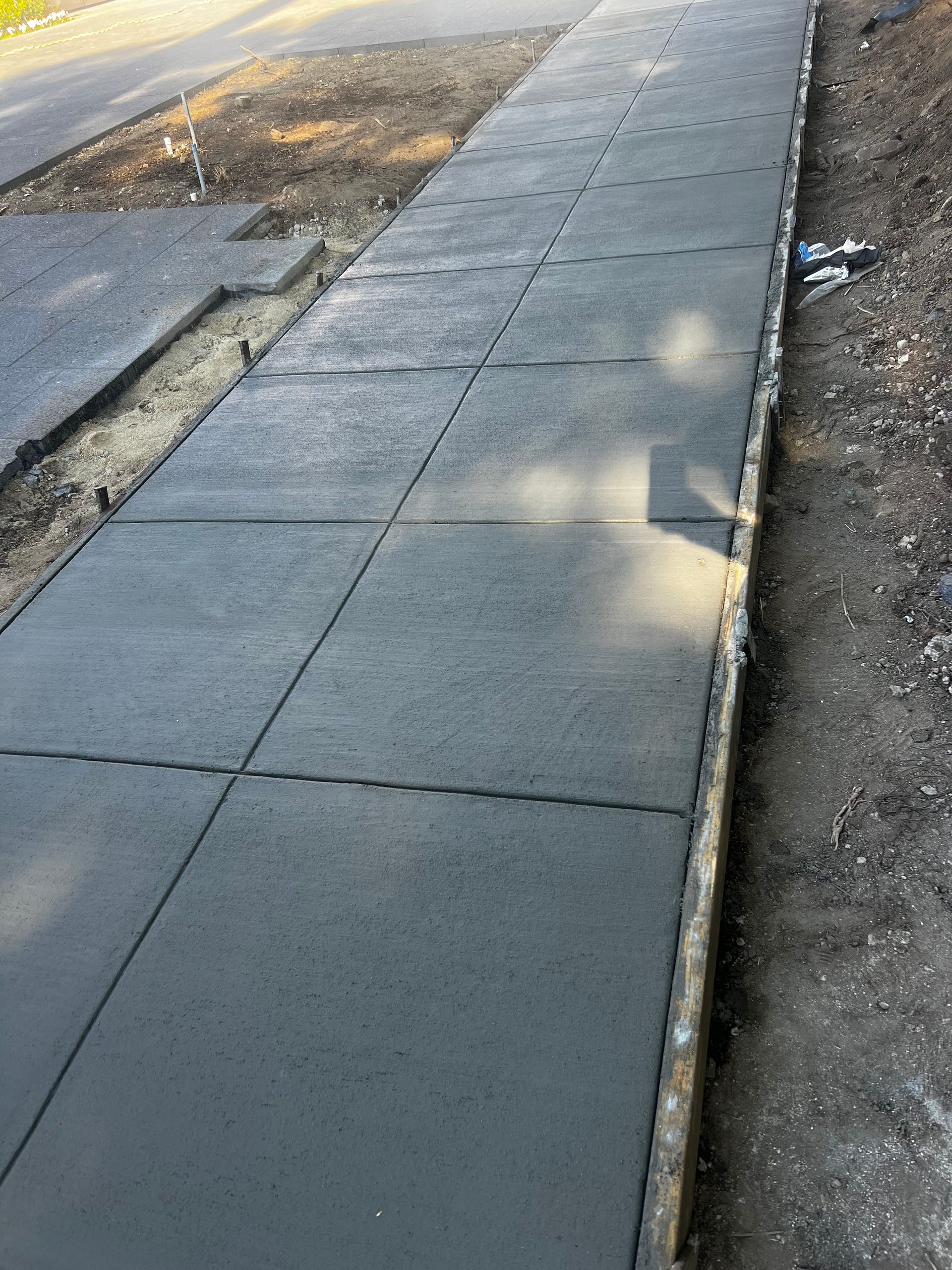 A concrete walkway is being built next to a road.