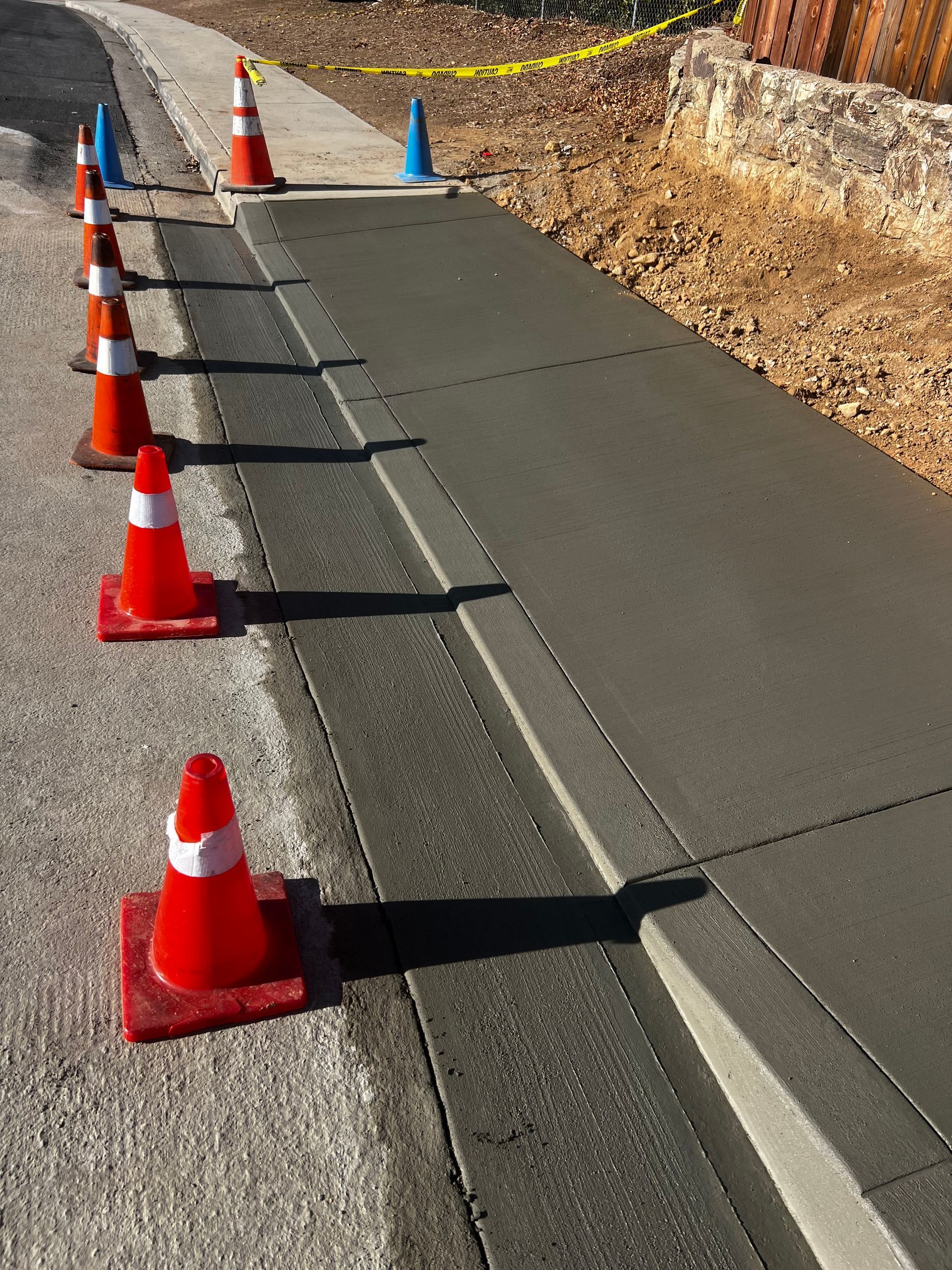 A row of orange and white traffic cones on a sidewalk