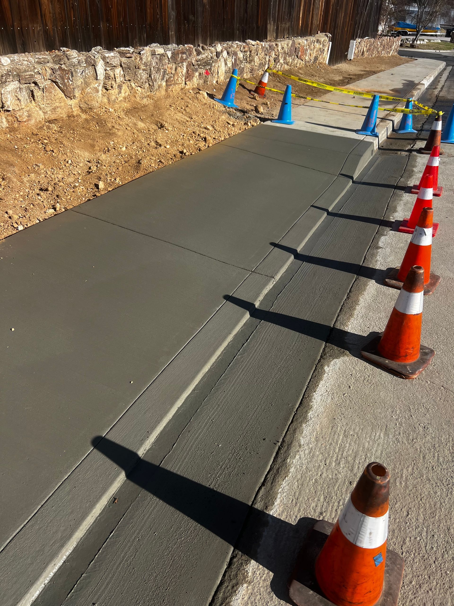 A row of orange and white traffic cones on a sidewalk
