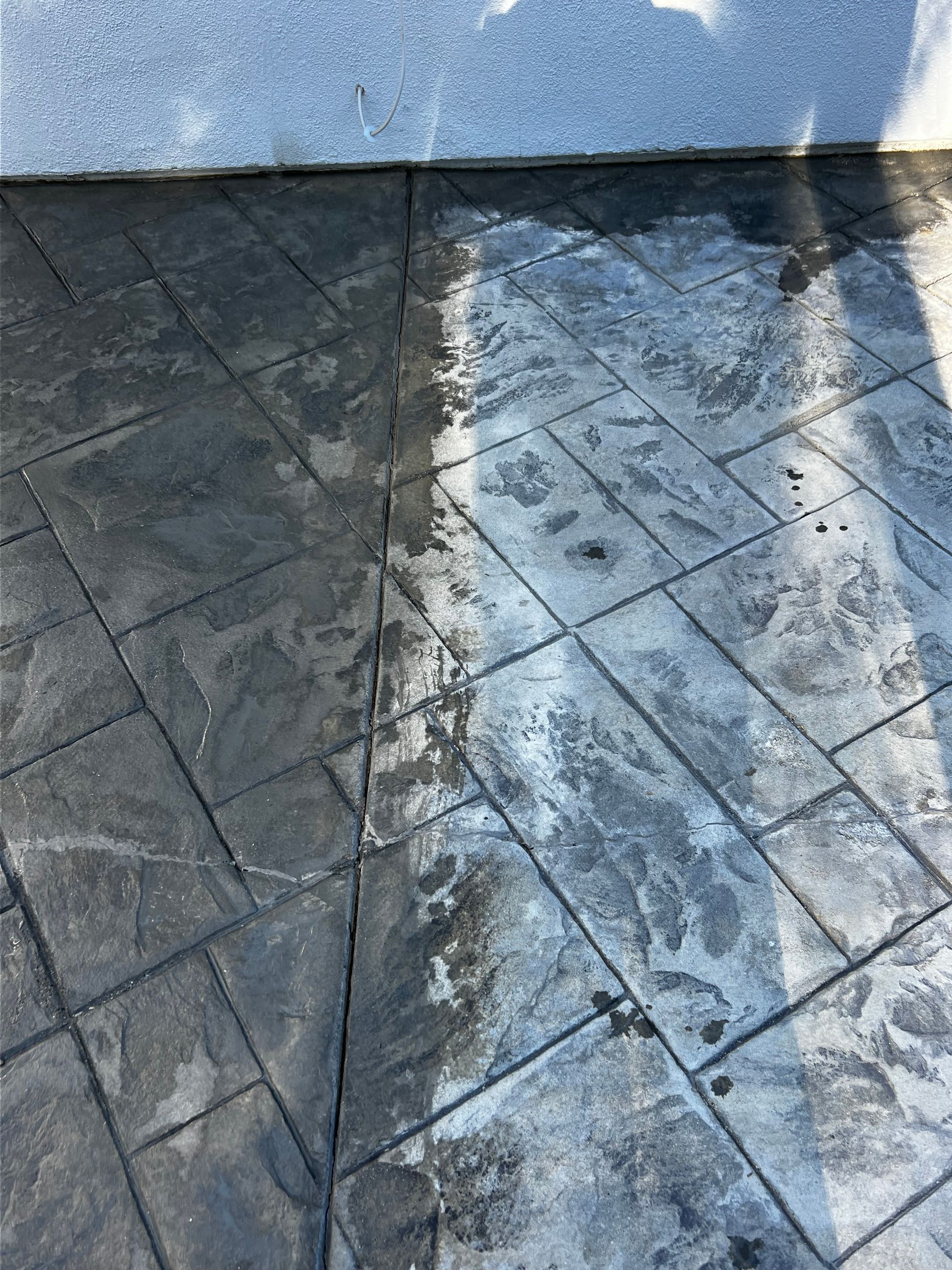 A concrete floor with a reflection of a building in the water.