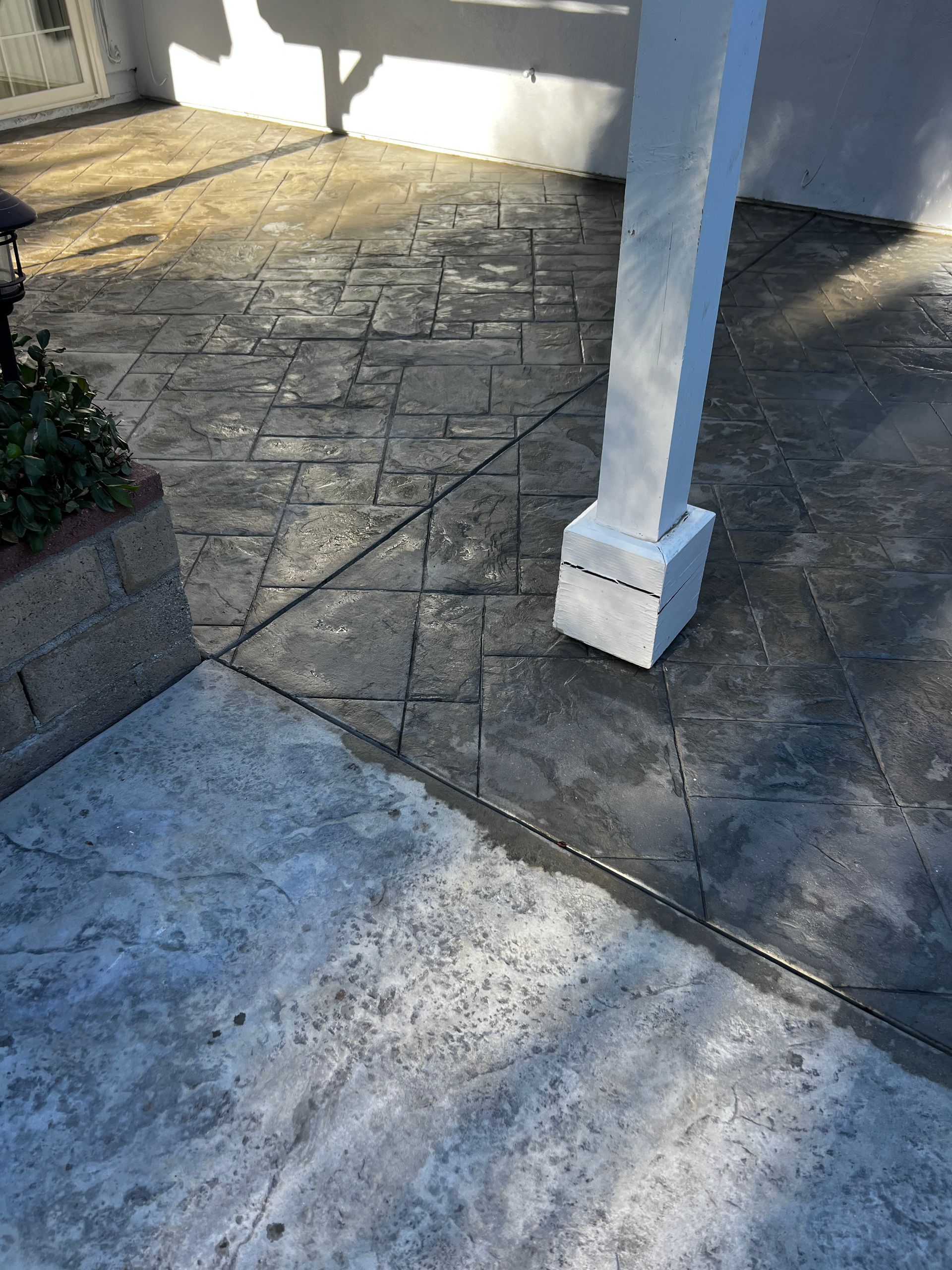 A concrete patio with a white pole in the middle of it.