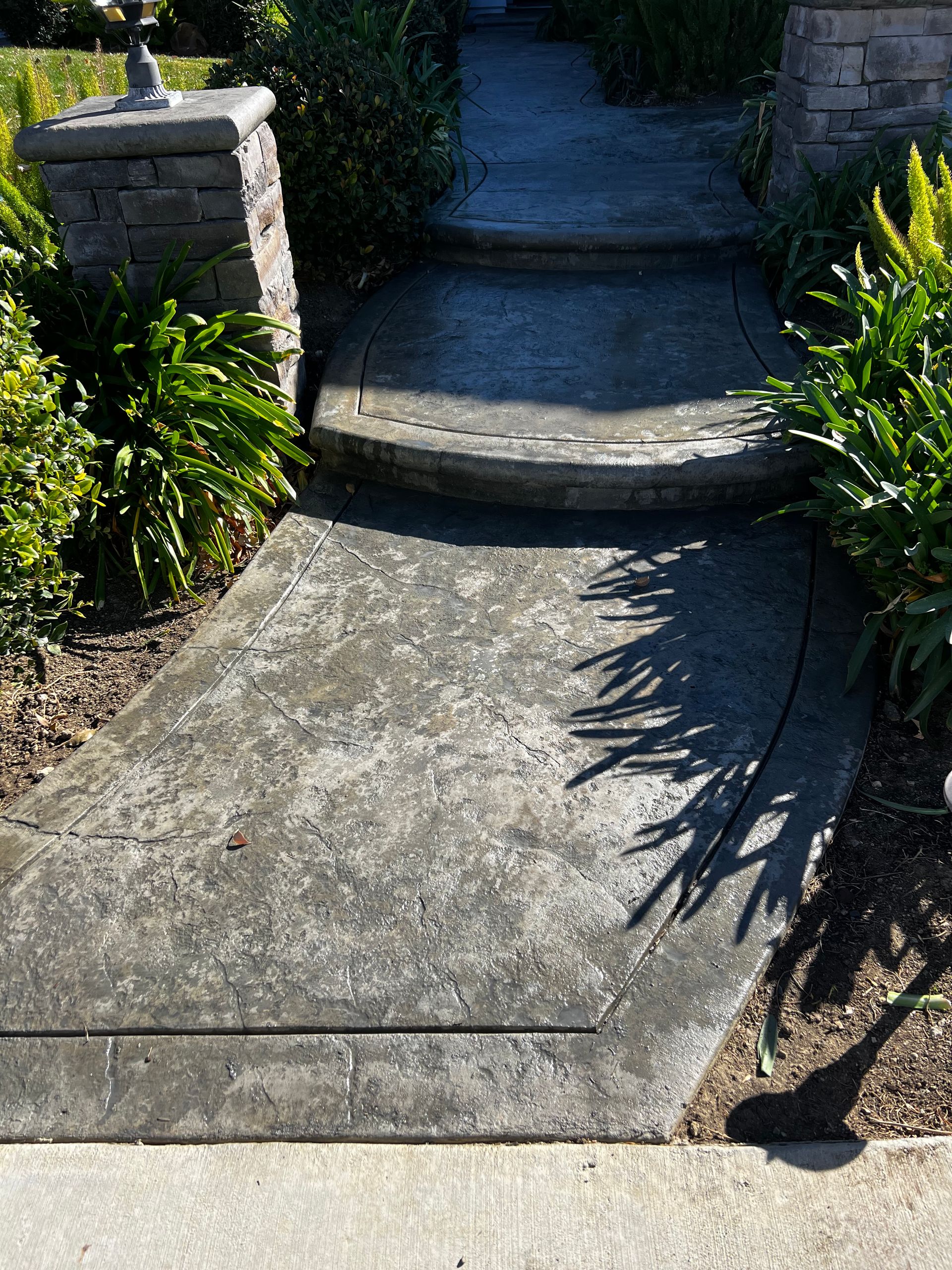 A concrete walkway with steps leading up to a house