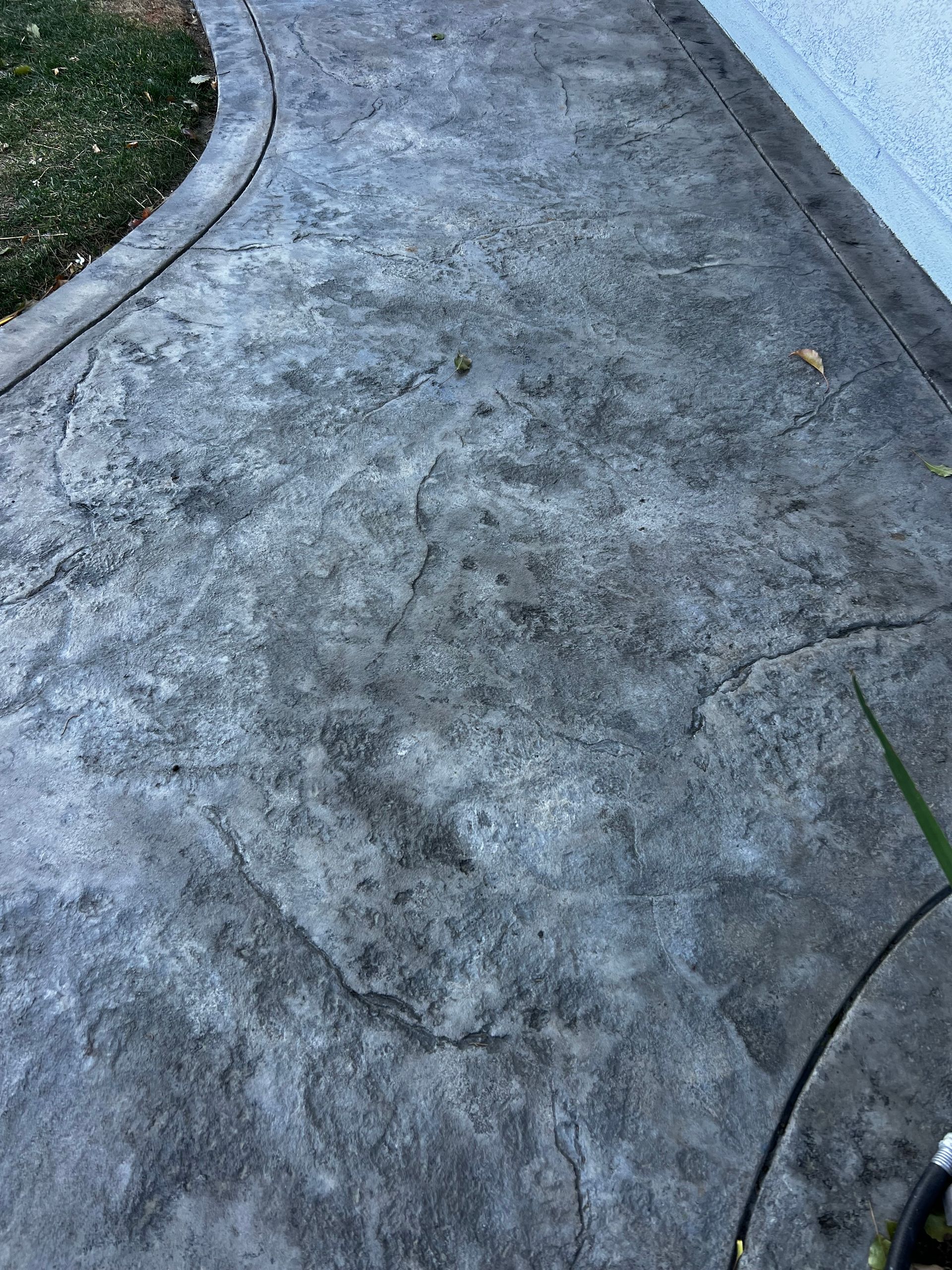 A close up of a concrete walkway next to a house.