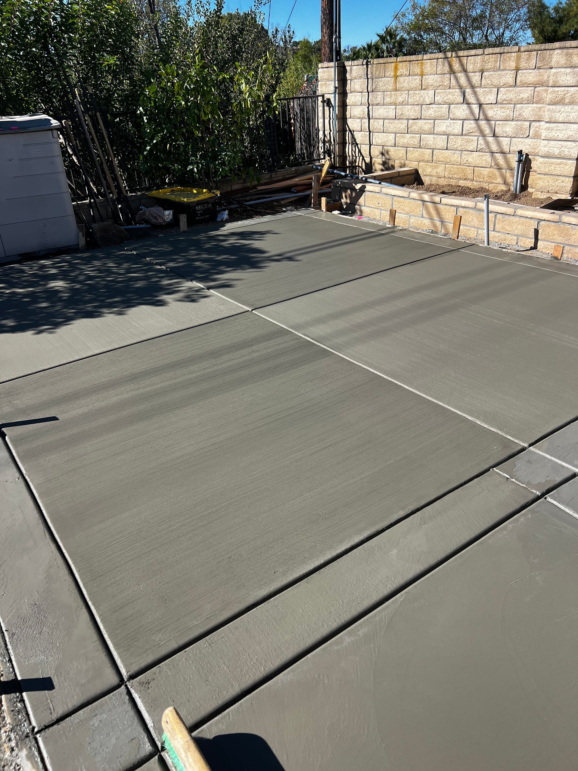 A concrete floor with a reflection of a building in the water.
