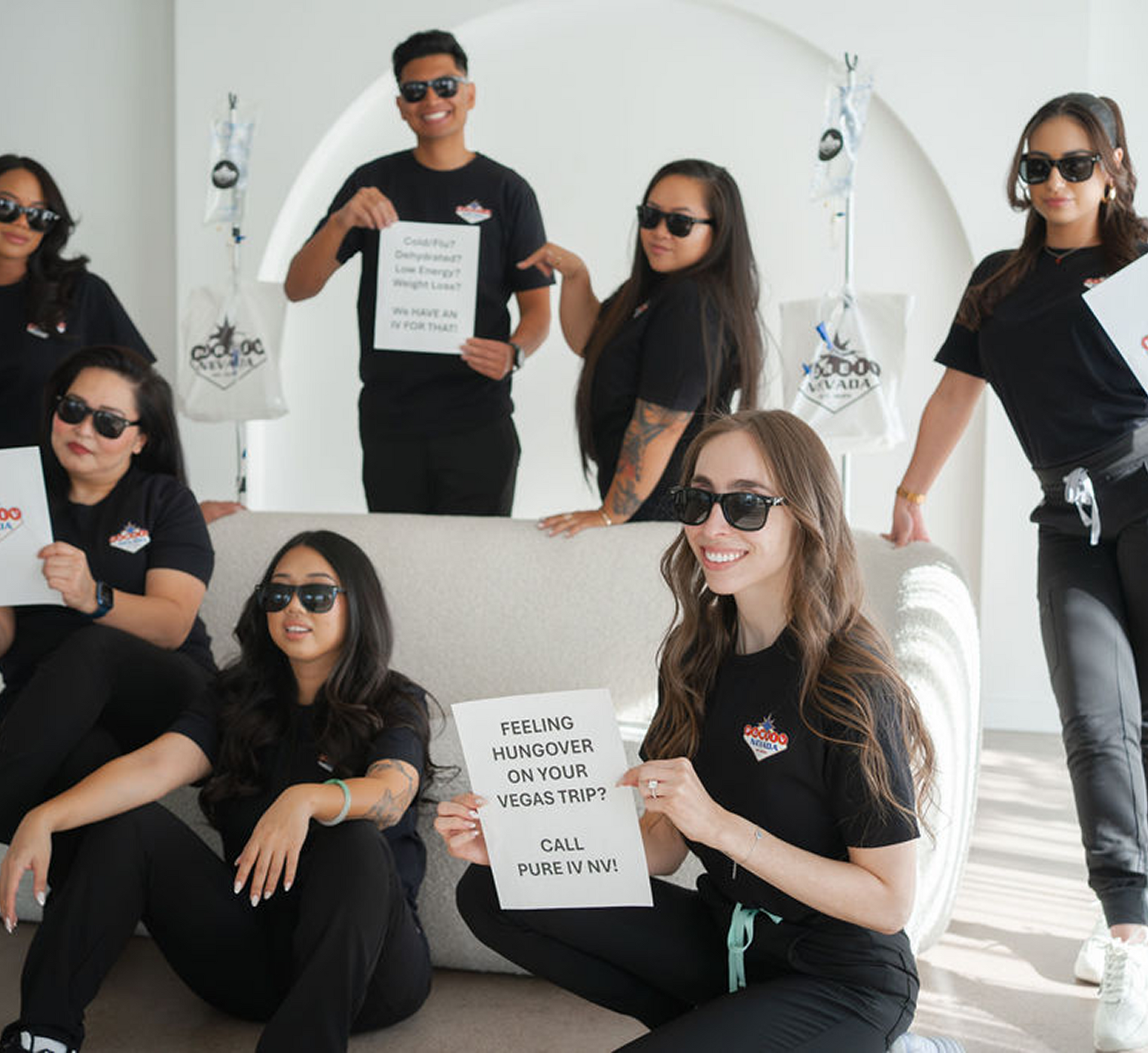 A group of people are posing for a picture and one of them is holding a piece of paper that says 