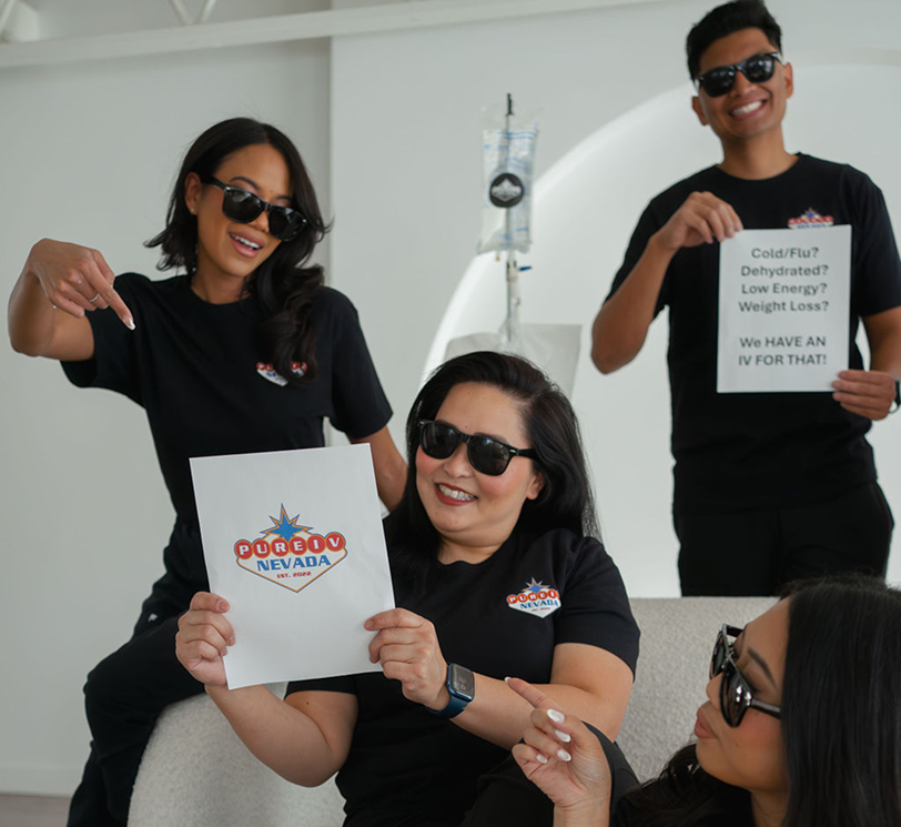 A group of people are posing for a picture and one woman is holding a sign that says ' coca cola ' on it