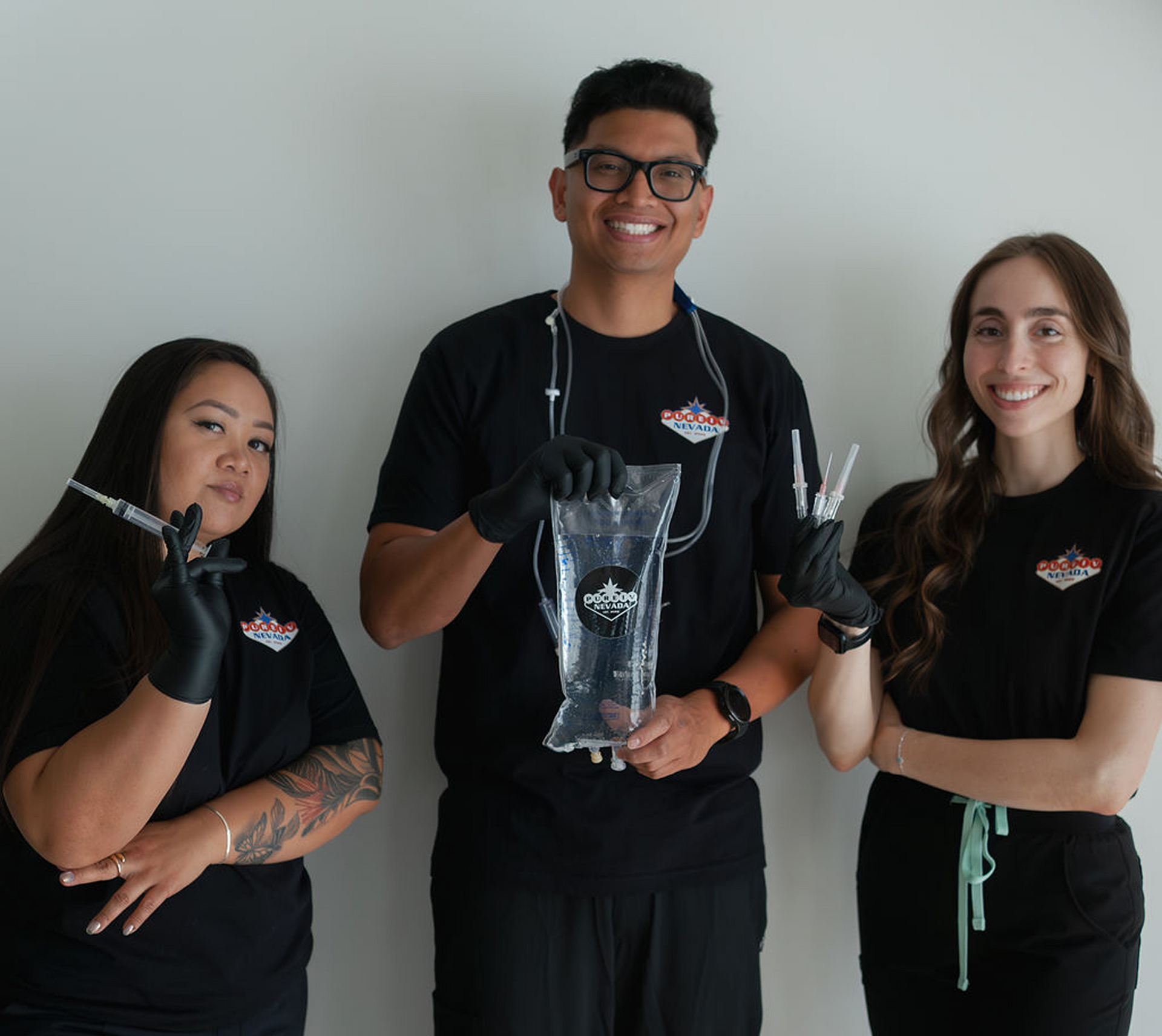 A man and two women standing next to each other holding a bag of water