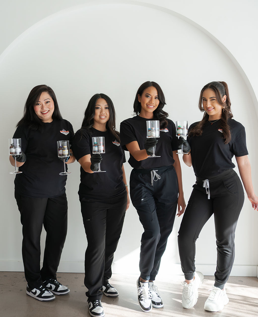 A group of women are standing next to each other holding wine glasses.