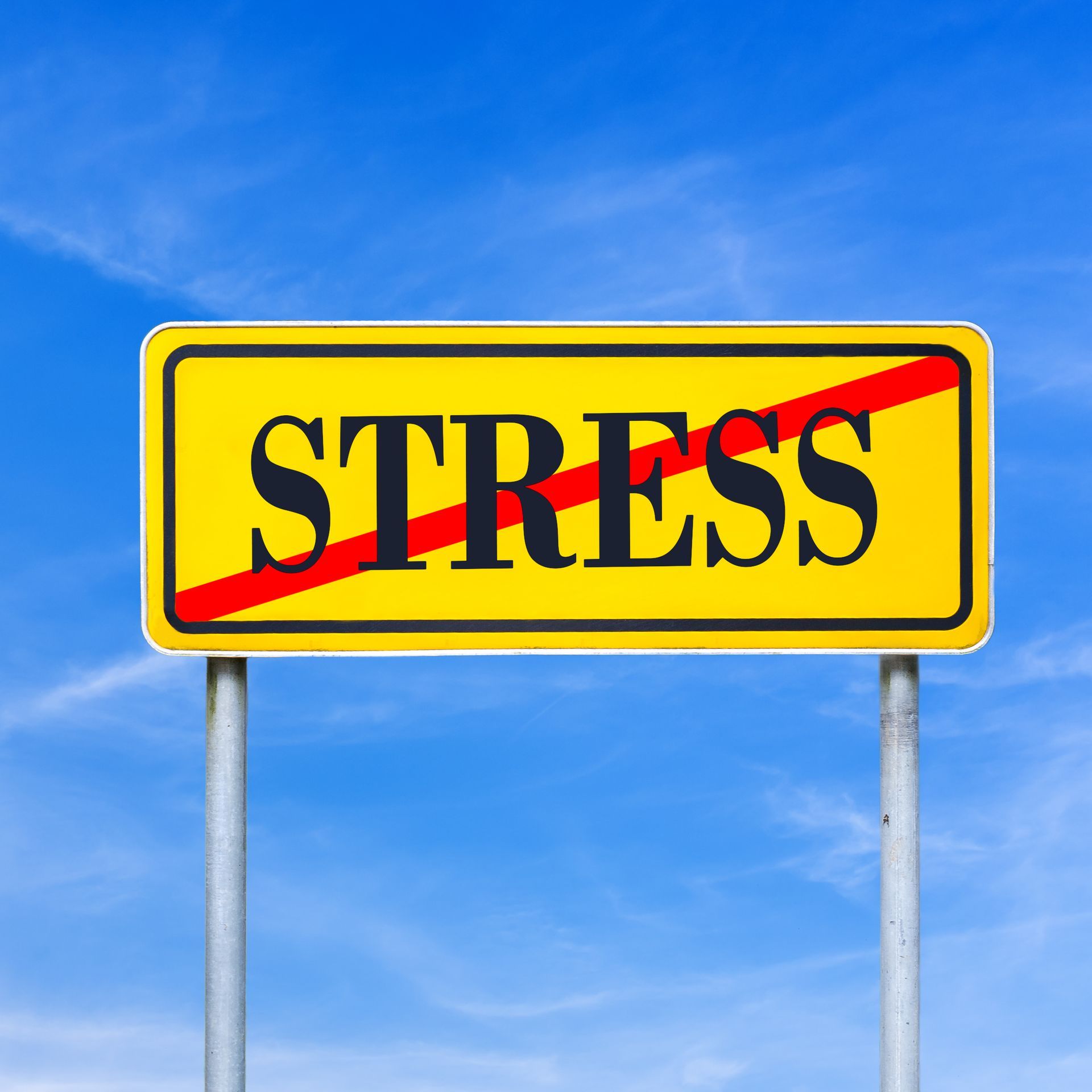 A yellow sign with the word stress crossed out with a red line.