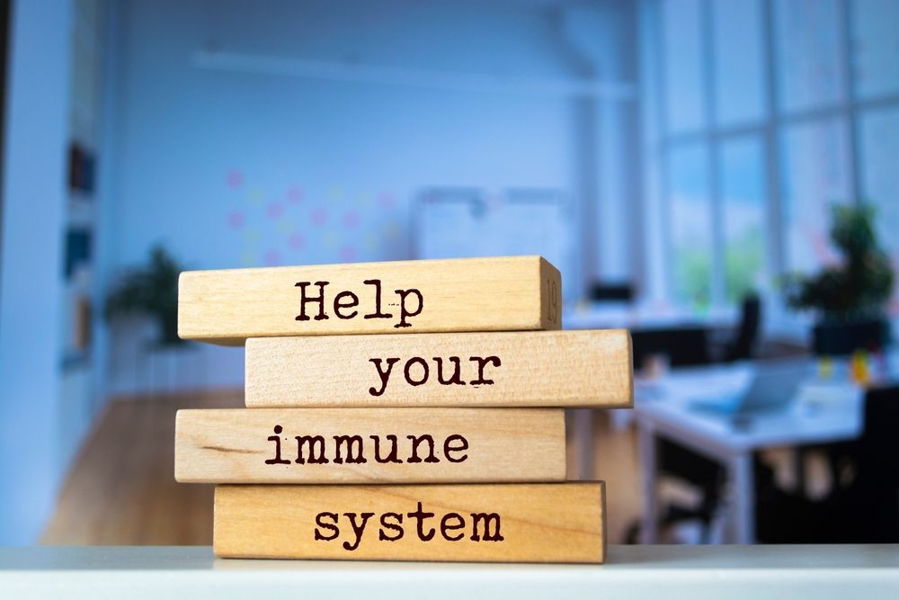 A stack of wooden blocks with the words `` help your immune system '' written on them.