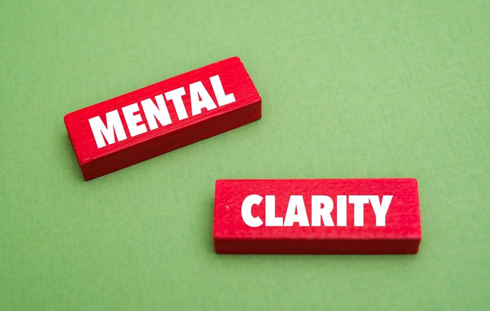 Two red blocks with the words mental and clarity written on them on a green background.