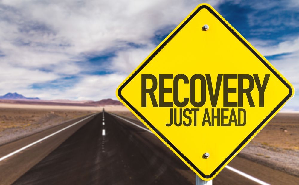 A yellow sign that says recovery just ahead