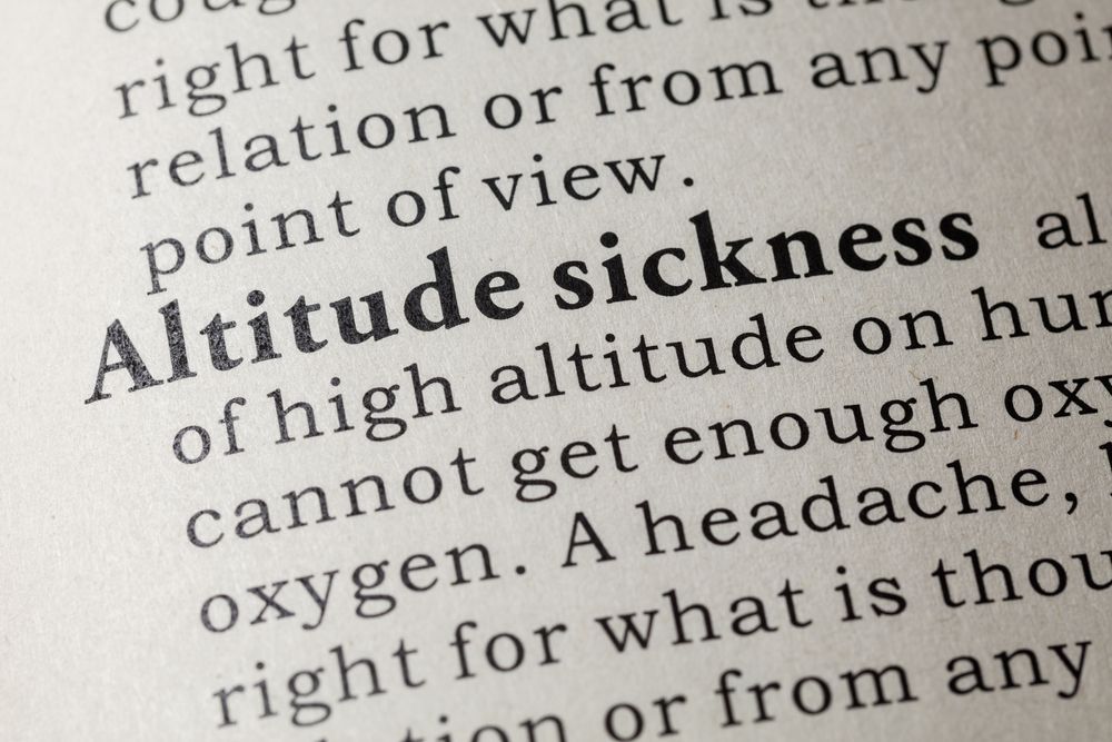 A book is open to a page that says altitude sickness