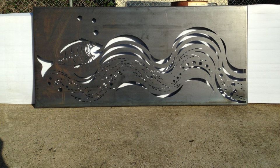 A piece of metal with a fish and waves on it