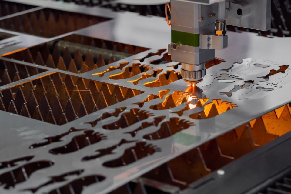 A machine is cutting a piece of metal with a laser.
