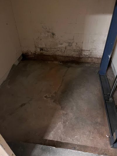 A room with a concrete floor and stairs in it.