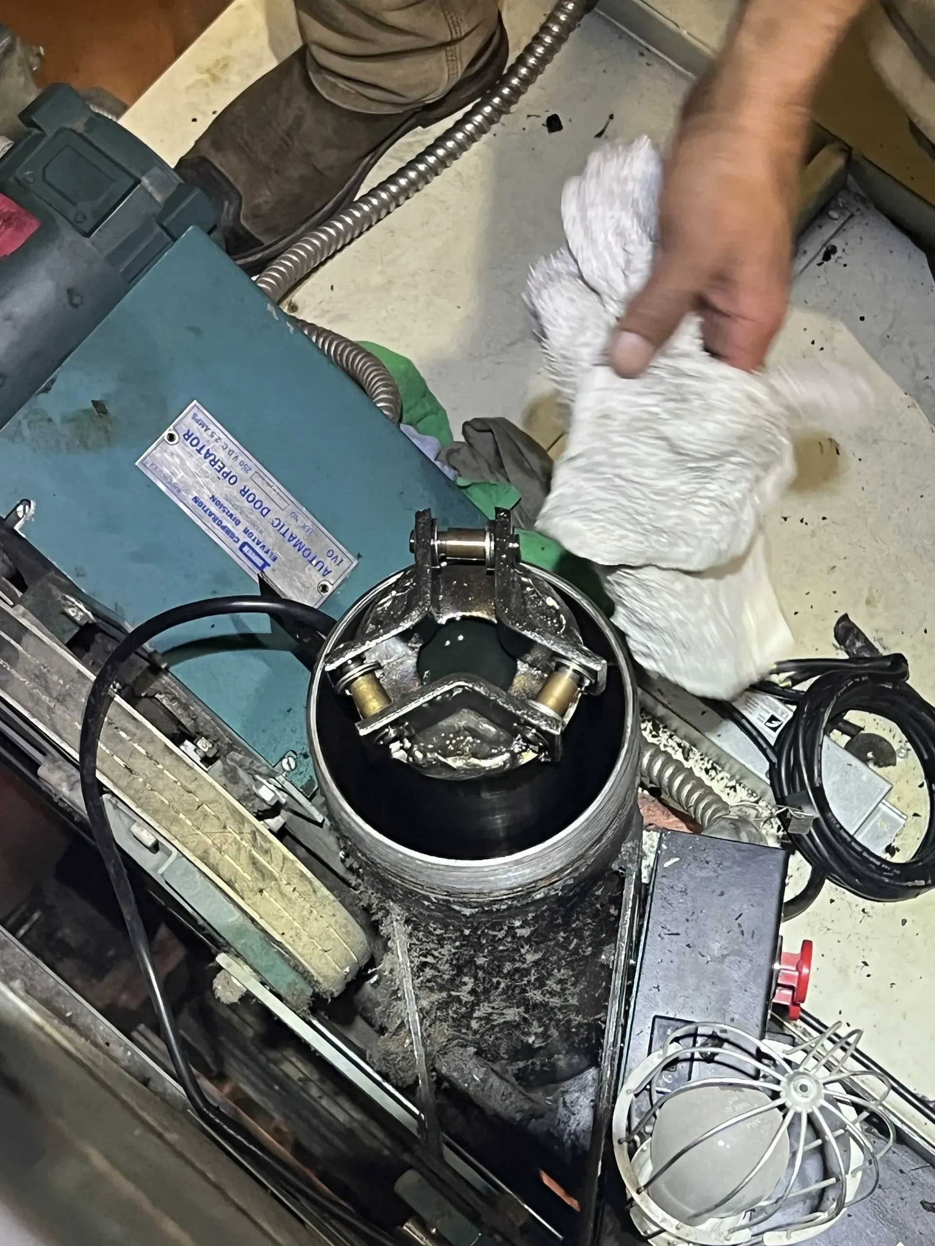 A person is cleaning a machine with a towel