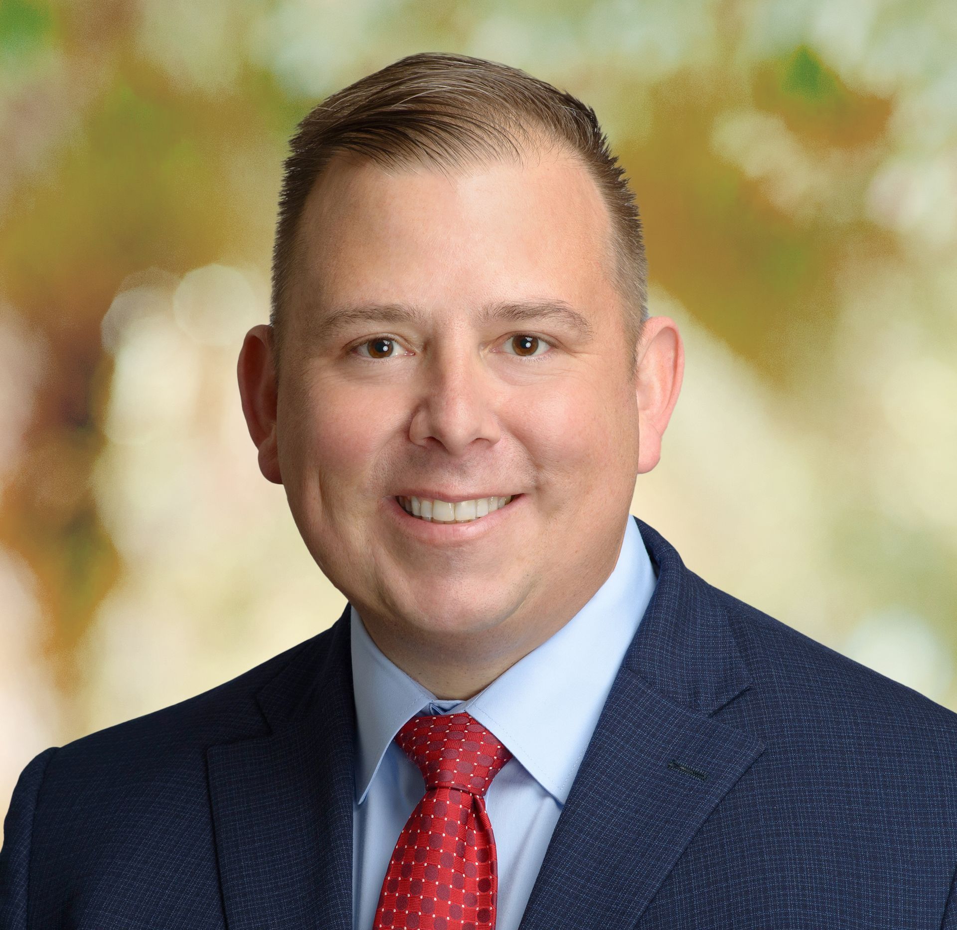 A man in a suit and tie is smiling for the camera.