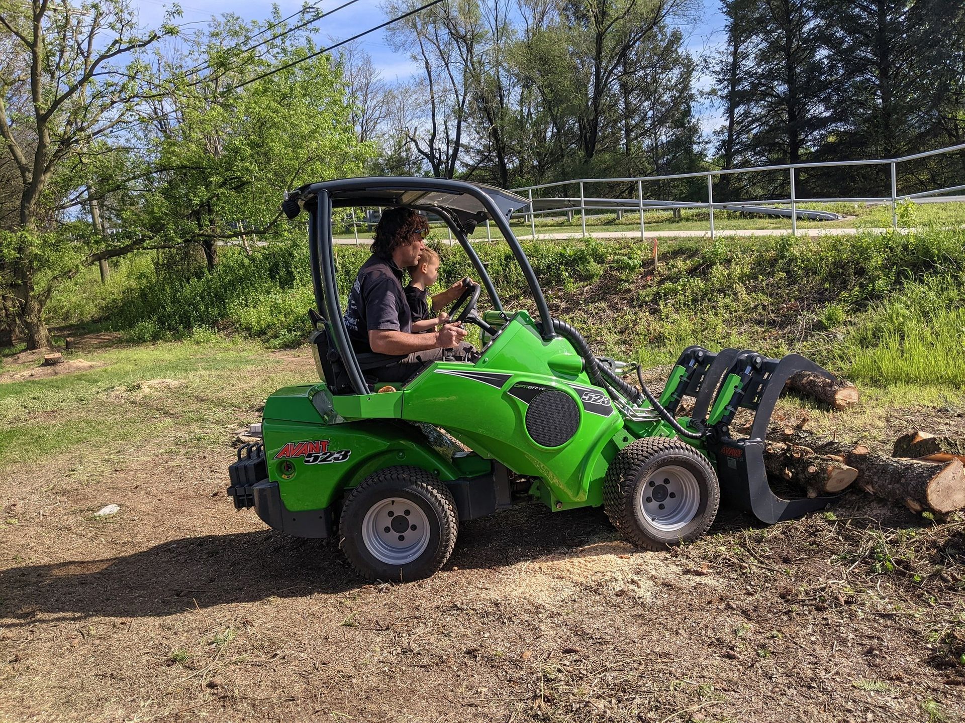 A man is driving a green tractor in a field.