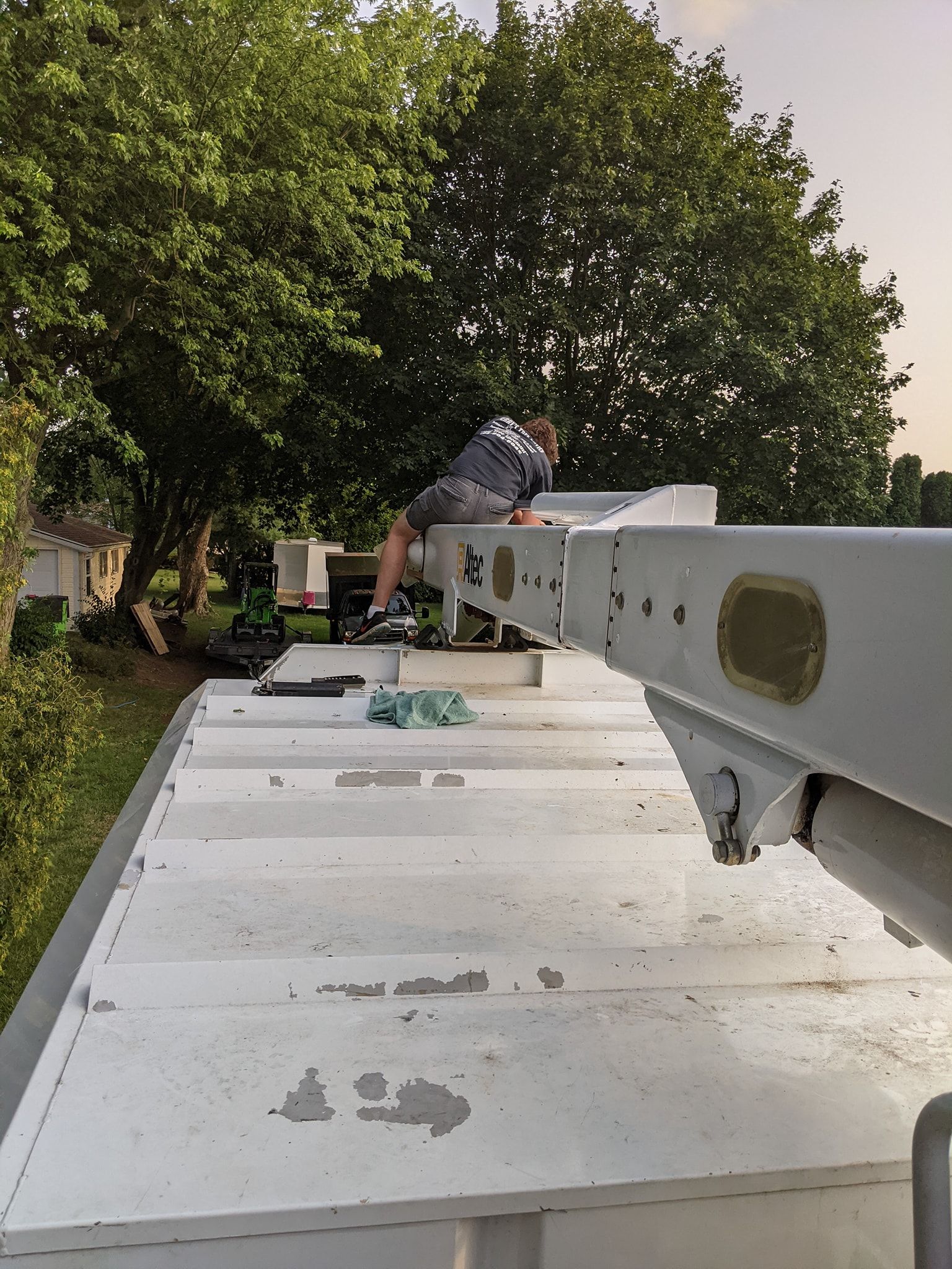 A man is sitting on top of a white roof.
