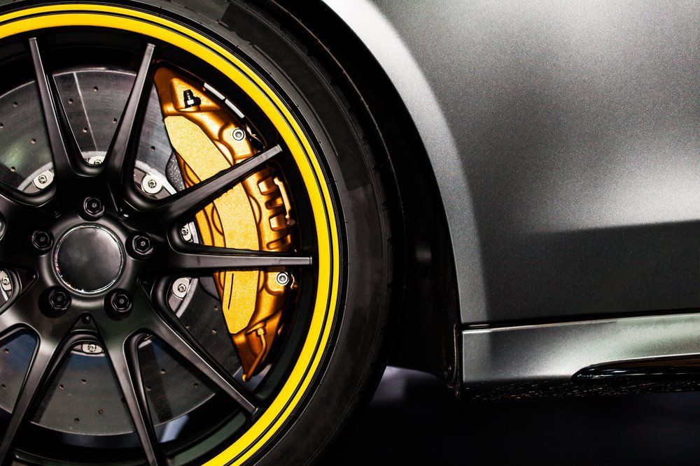 A Close Up of a Car Wheel With a Yellow Rim and Brakes — Forster Mechanical Repairs & Servicing In Forster, NSW