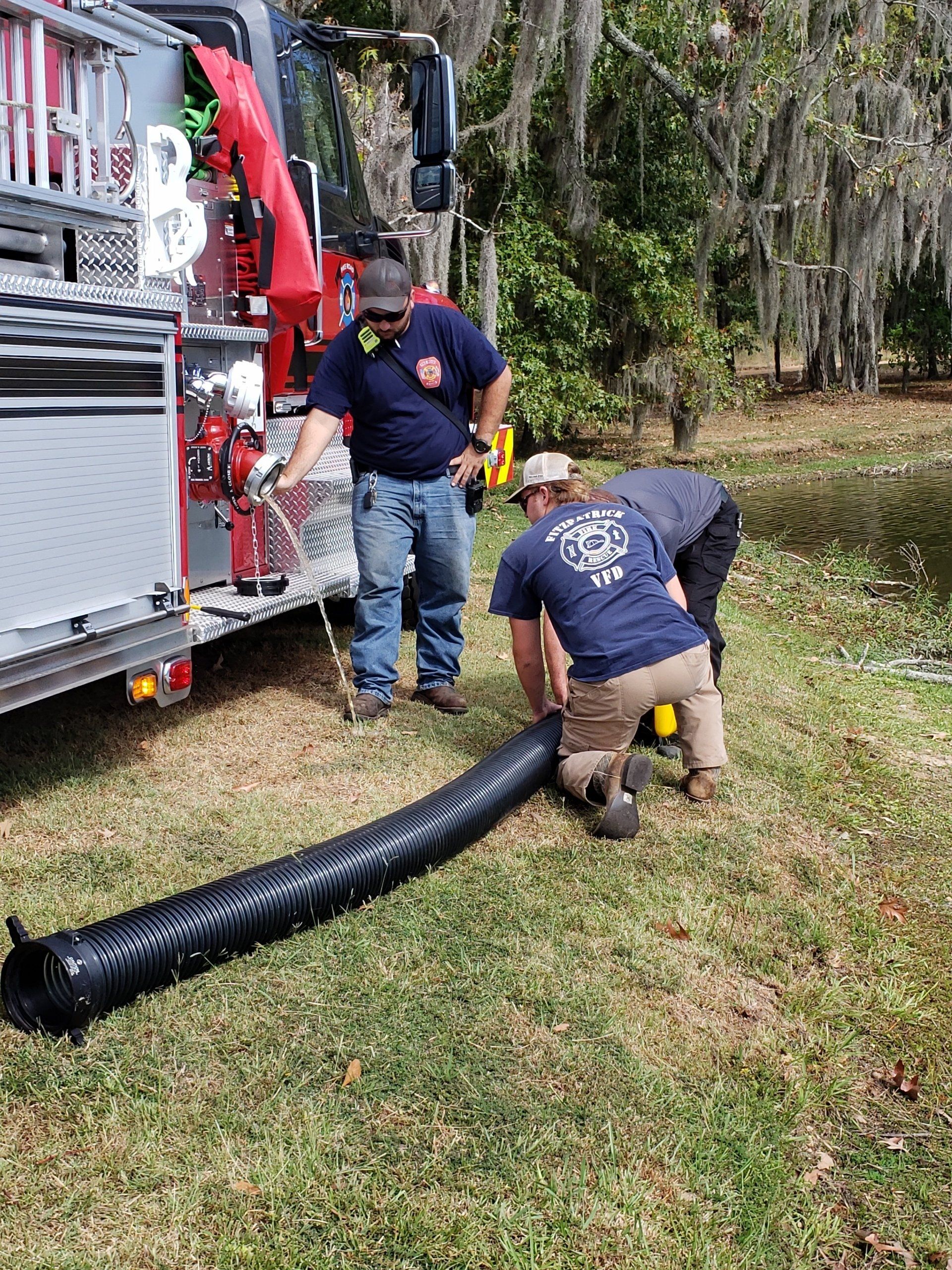 A group of firefighters are working on a fire truck.