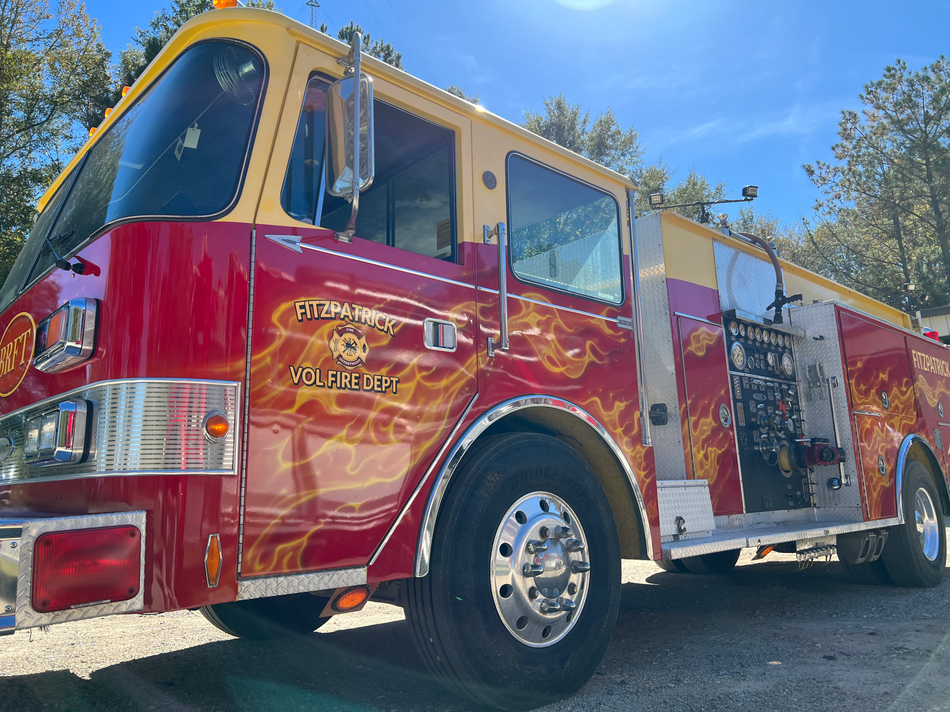 A red and yellow fire truck with flames painted on it